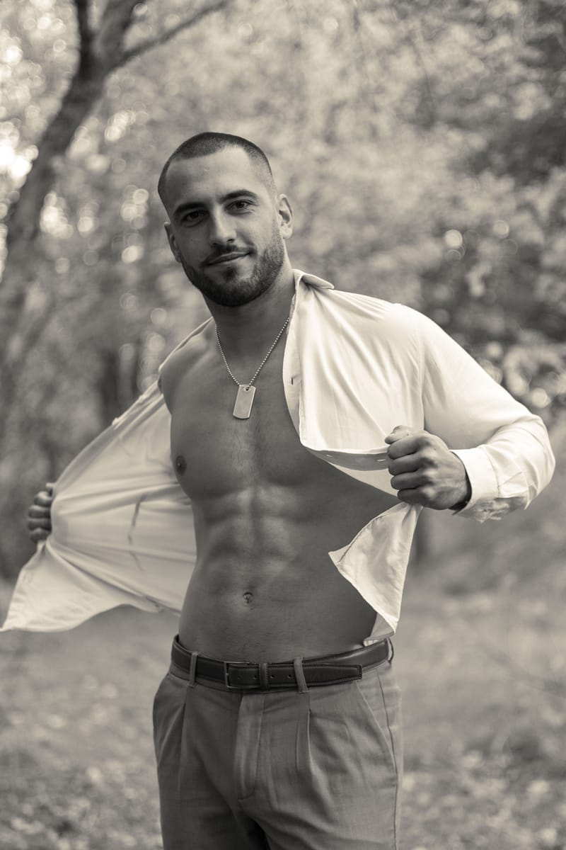 Jeremy Pouch ouvrant sa chemise blanche, en noir et blanc